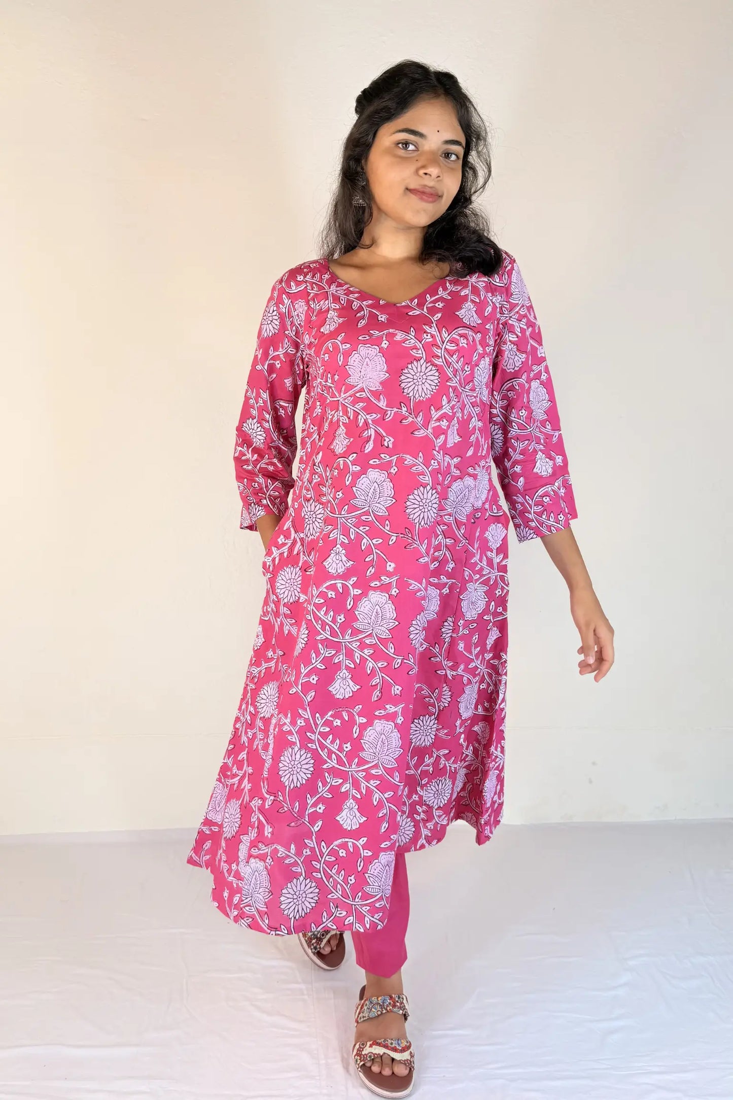 Woman wearing a pink floral dress against a white background