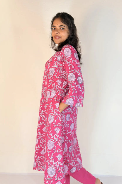 Woman wearing a pink floral dress against a white background