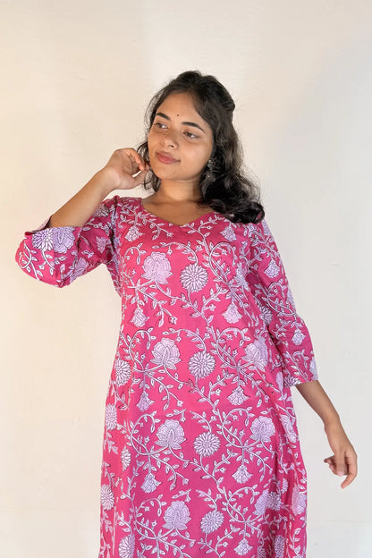 Woman wearing a pink floral dress against a white background