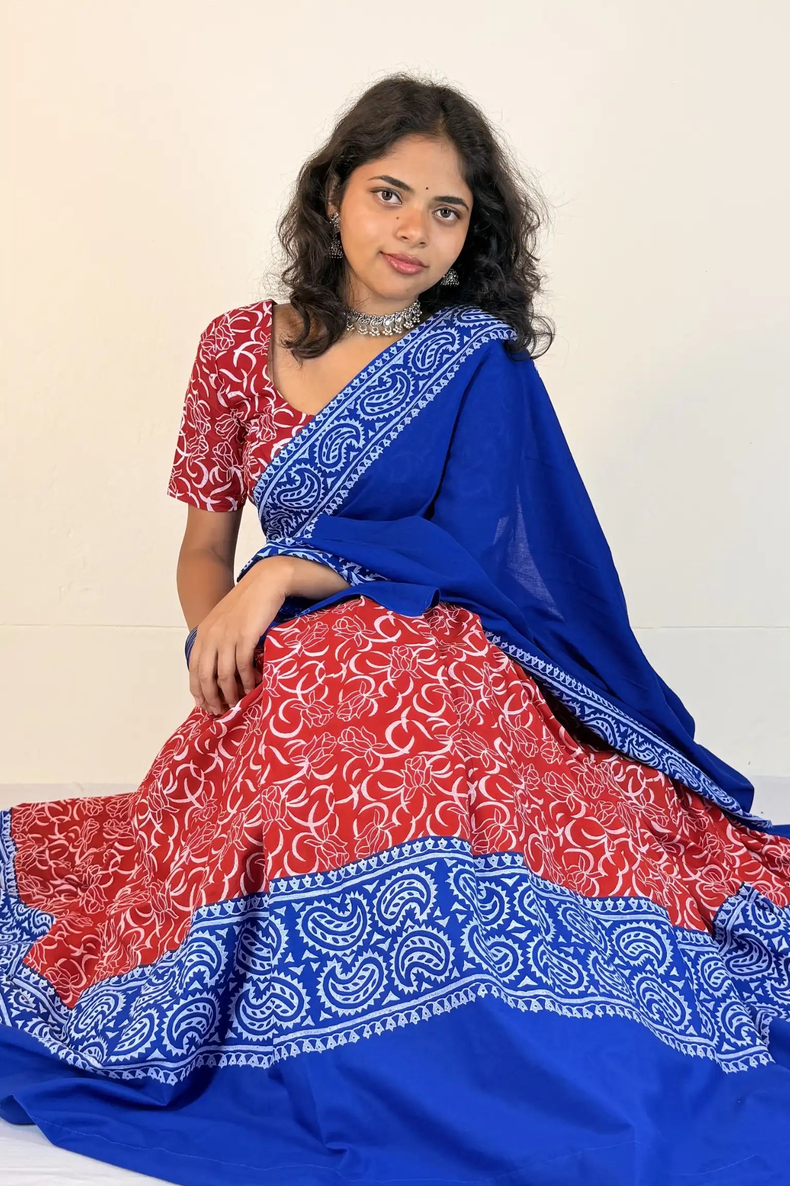 Woman wearing a blue and red traditional outfit with a white background