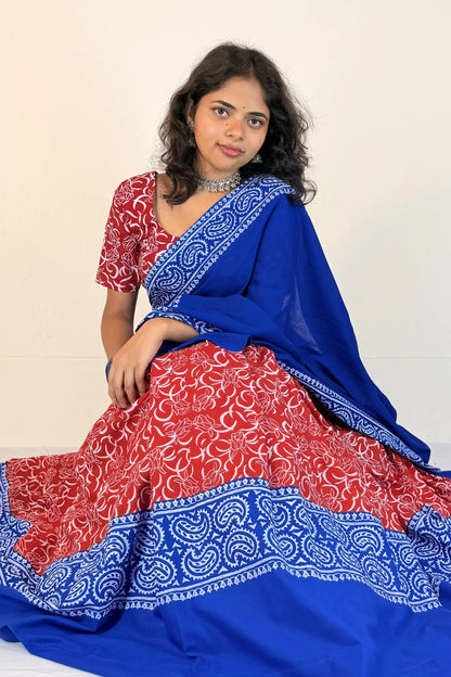 Woman wearing a blue and red traditional outfit with a white background
