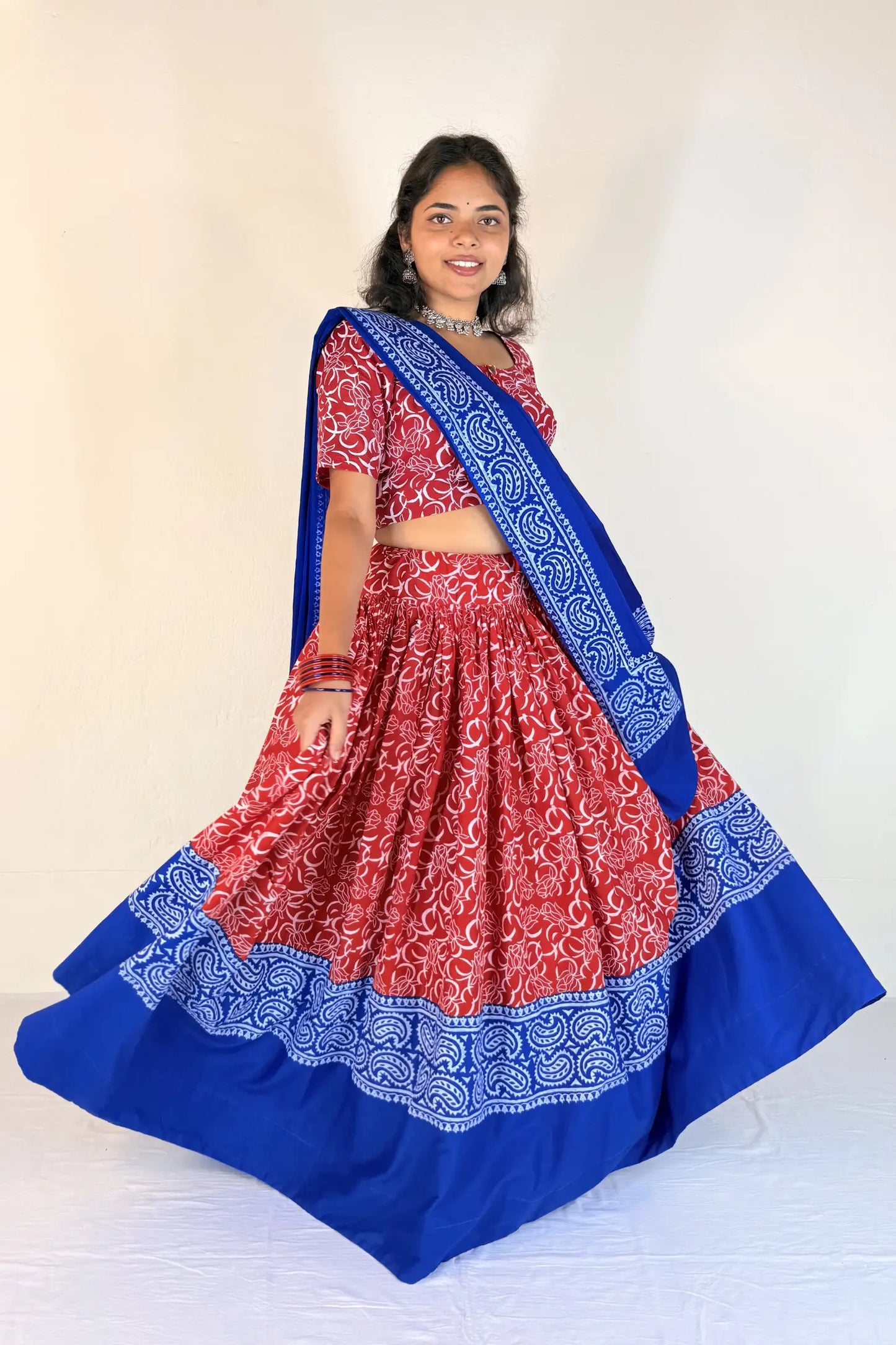 Woman wearing a blue and red traditional outfit with a white background