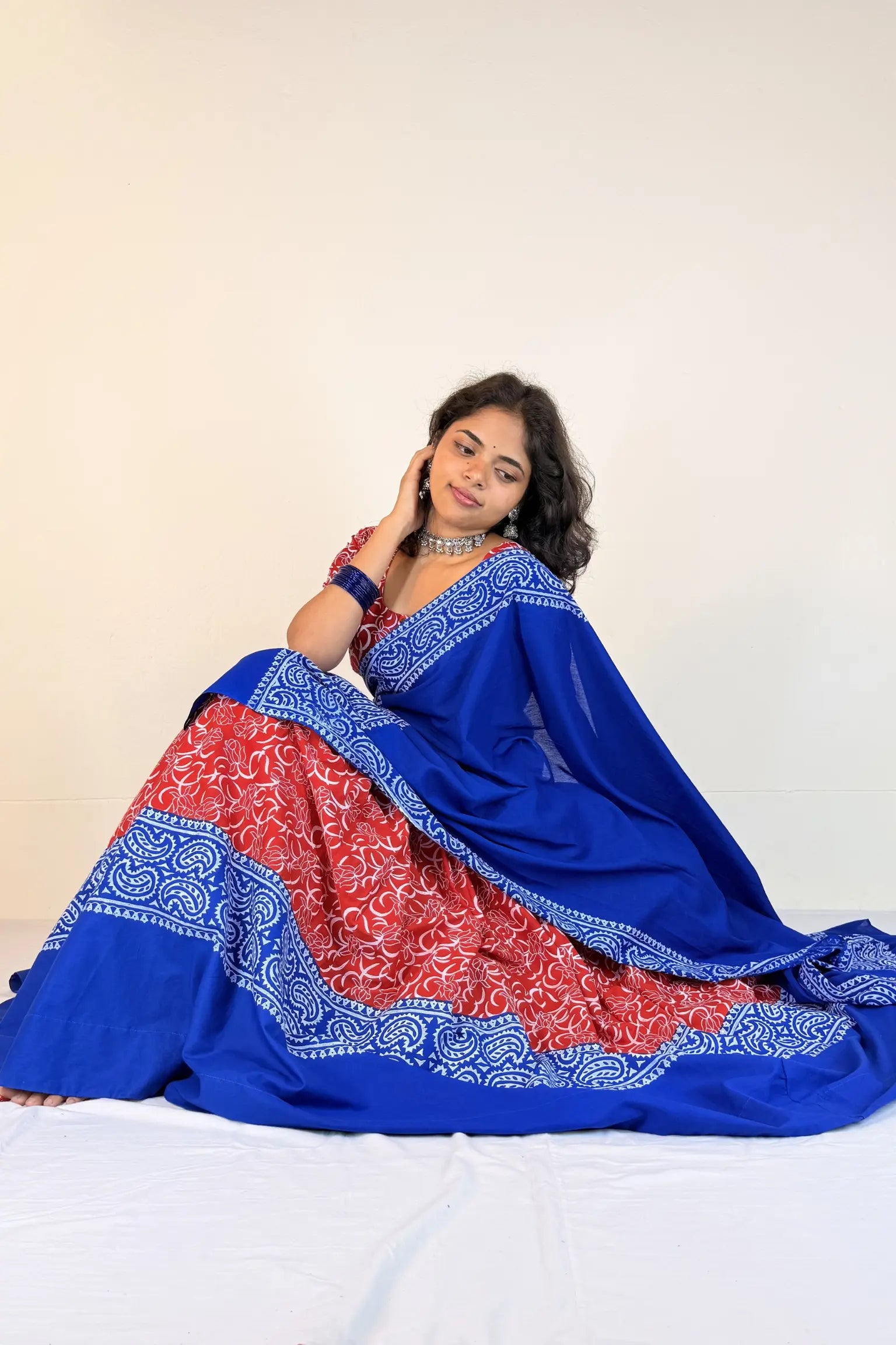 Woman wearing a blue and red Gopi Dress with a white background
