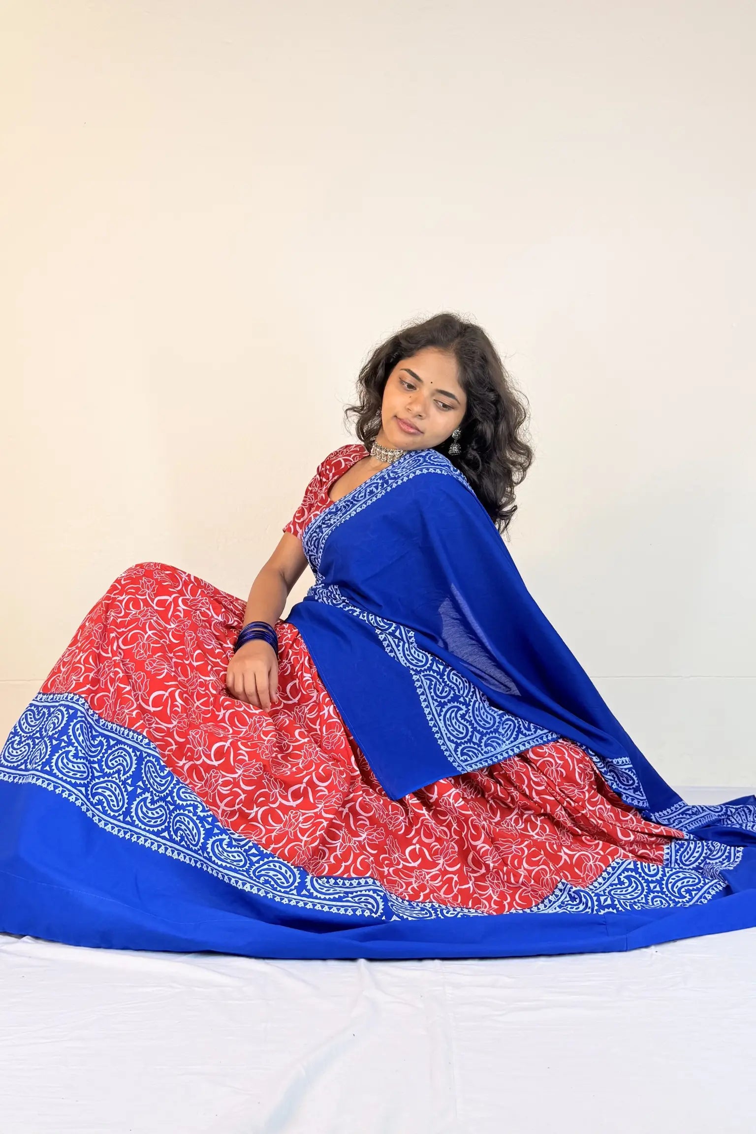 Woman wearing a red and blue Gopi Dress with a white background