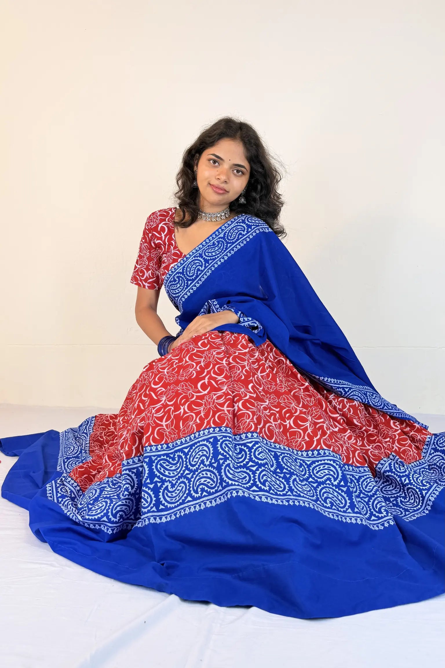 Woman wearing a blue and red Gopi Dress with a white background