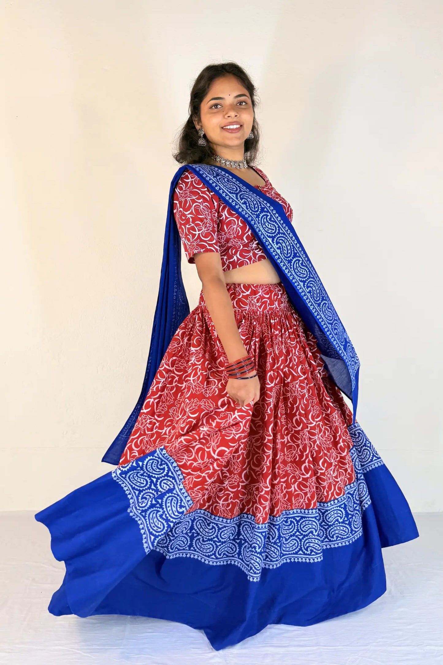 Woman wearing a blue and red traditional outfit with a white background