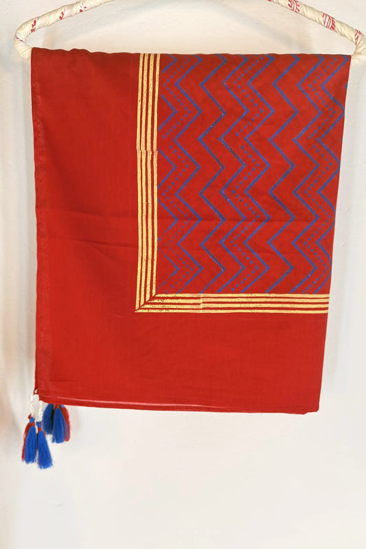 Red cotton scarf with geometric block print in brown and gold, featuring fine line detailing and handcrafted tassels