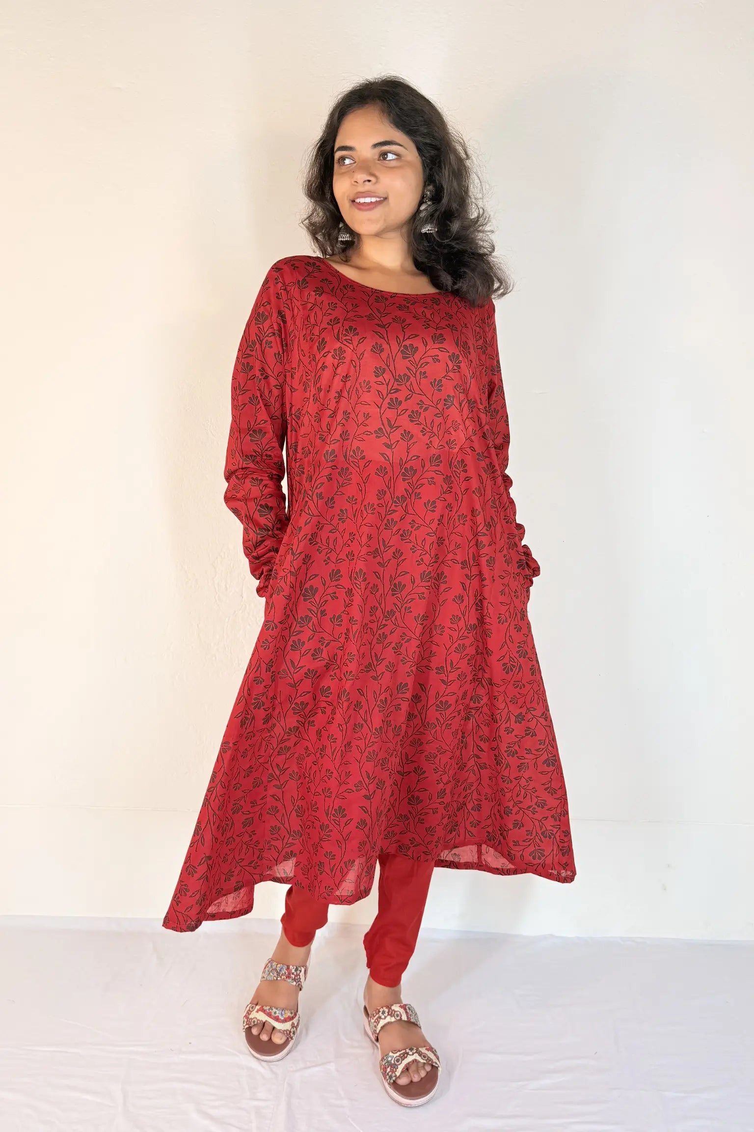 Woman wearing a red patterned dress against a white background
