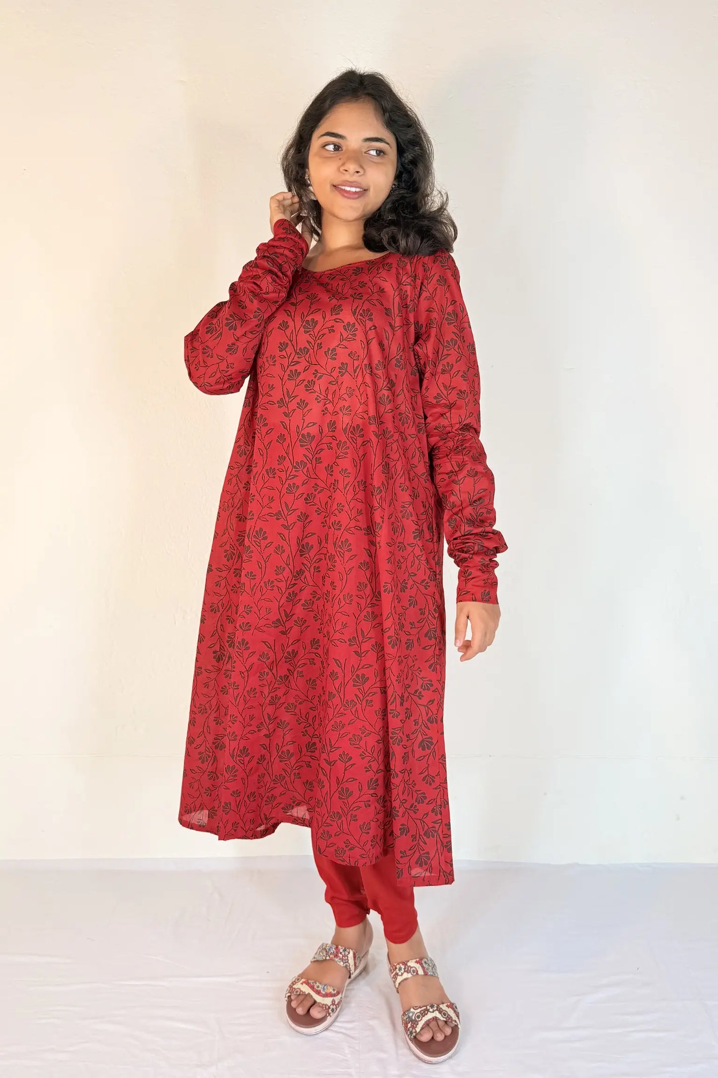 Woman wearing a red traditional outfit with a white background