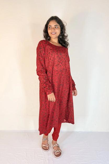 Woman wearing a red patterned dress against a white background