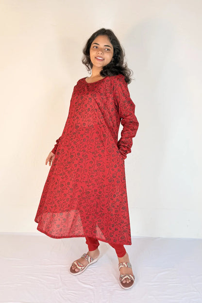 Woman wearing a red patterned dress on a white background