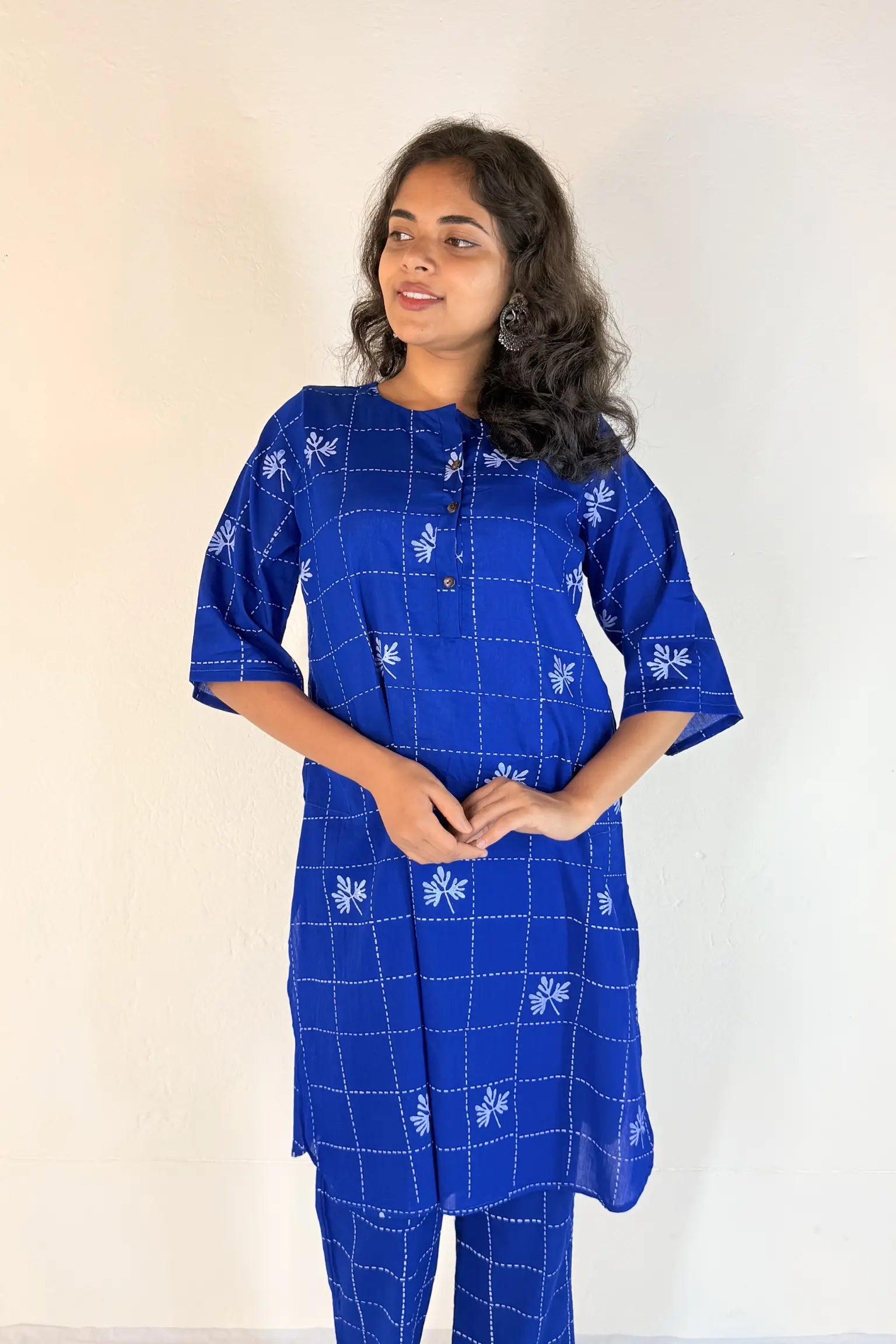Woman wearing a blue patterned kurta with matching pants against a white background