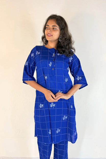 Woman wearing a blue patterned kurta with matching pants against a white background