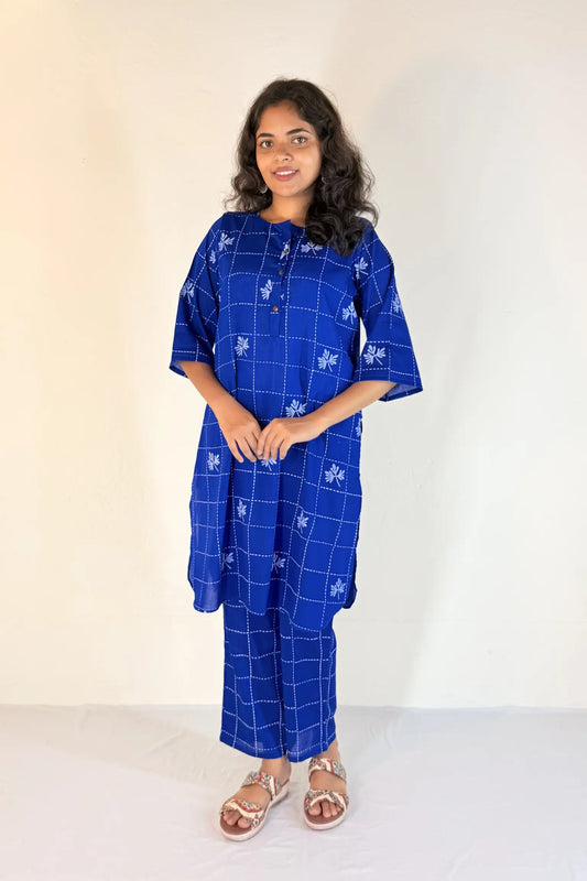 Woman wearing a blue patterned outfit against a white background
