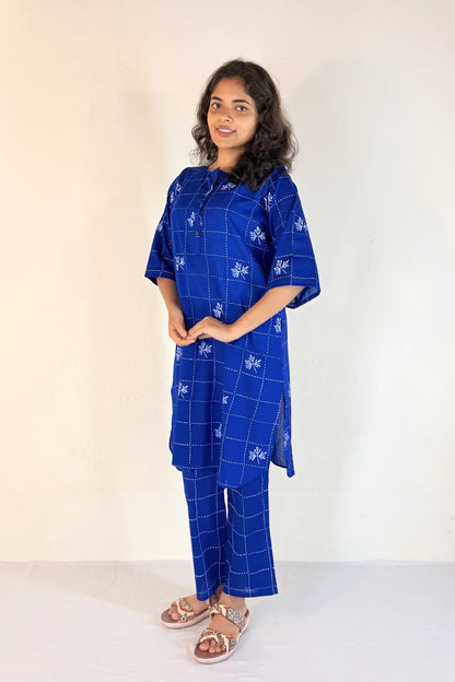 Woman wearing a blue checkered outfit against a white background