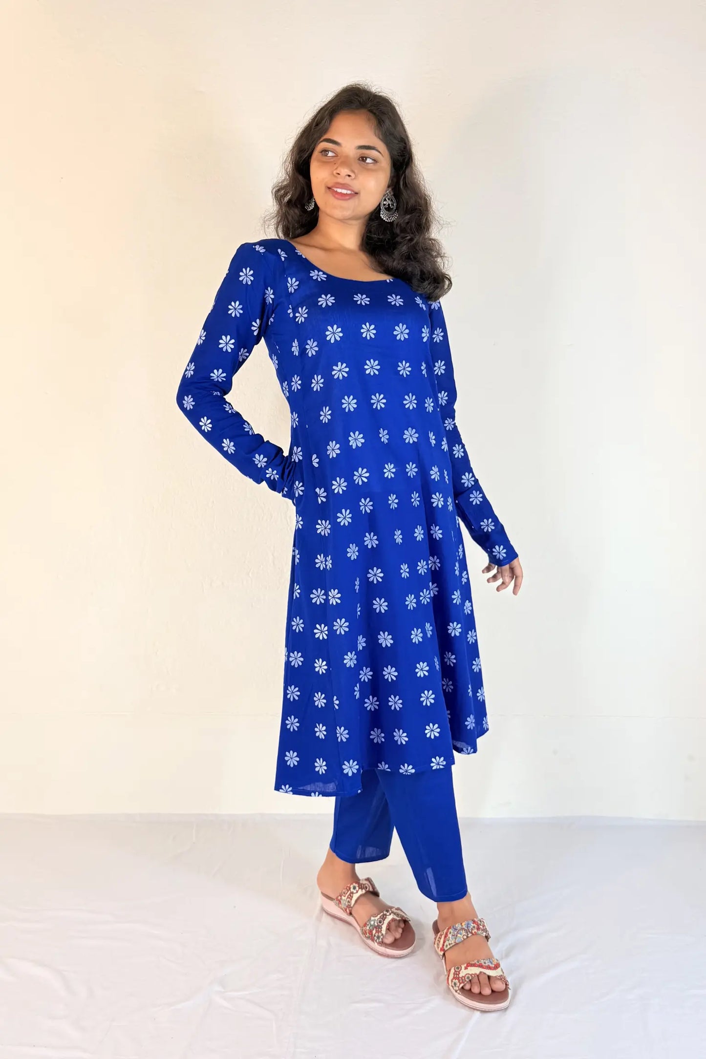 Woman wearing a blue floral dress against a white background