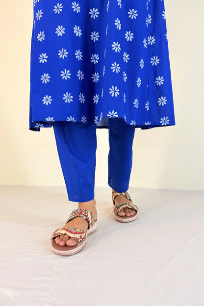 Blue floral dress with matching pants and sandals on a white background