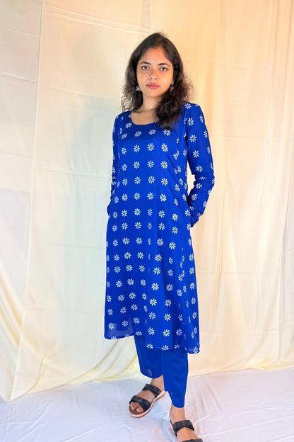 Woman wearing a blue floral dress against a white background