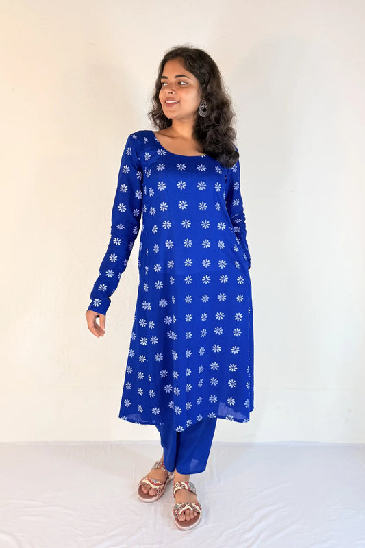 Woman wearing a blue kurta with white floral patterns on a white background