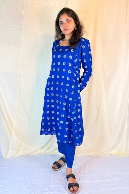 Woman wearing a blue floral dress against a white background