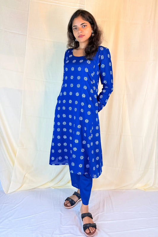 Woman wearing a blue floral dress against a white background