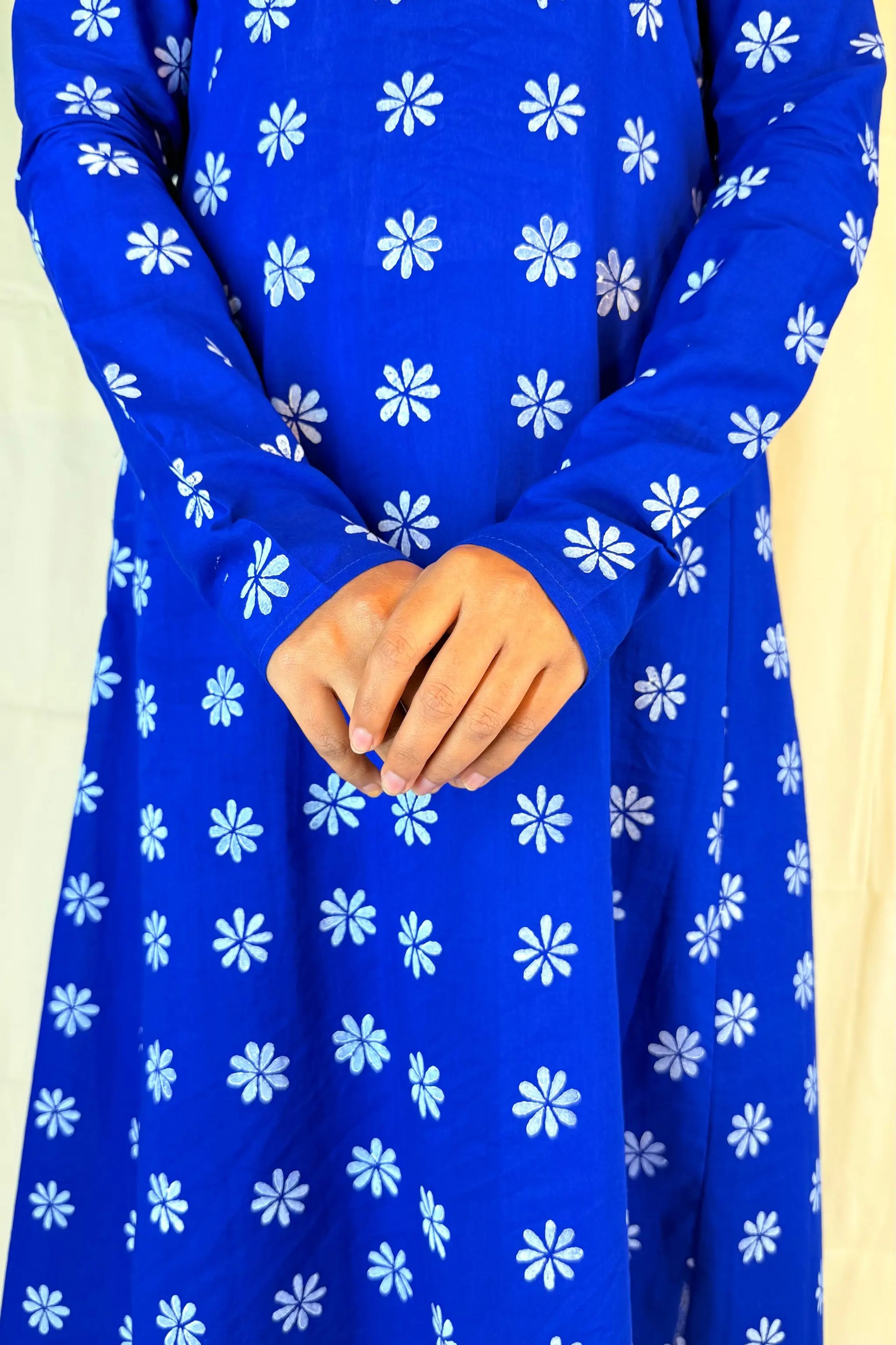 Blue dress with white floral patterns on a beige background