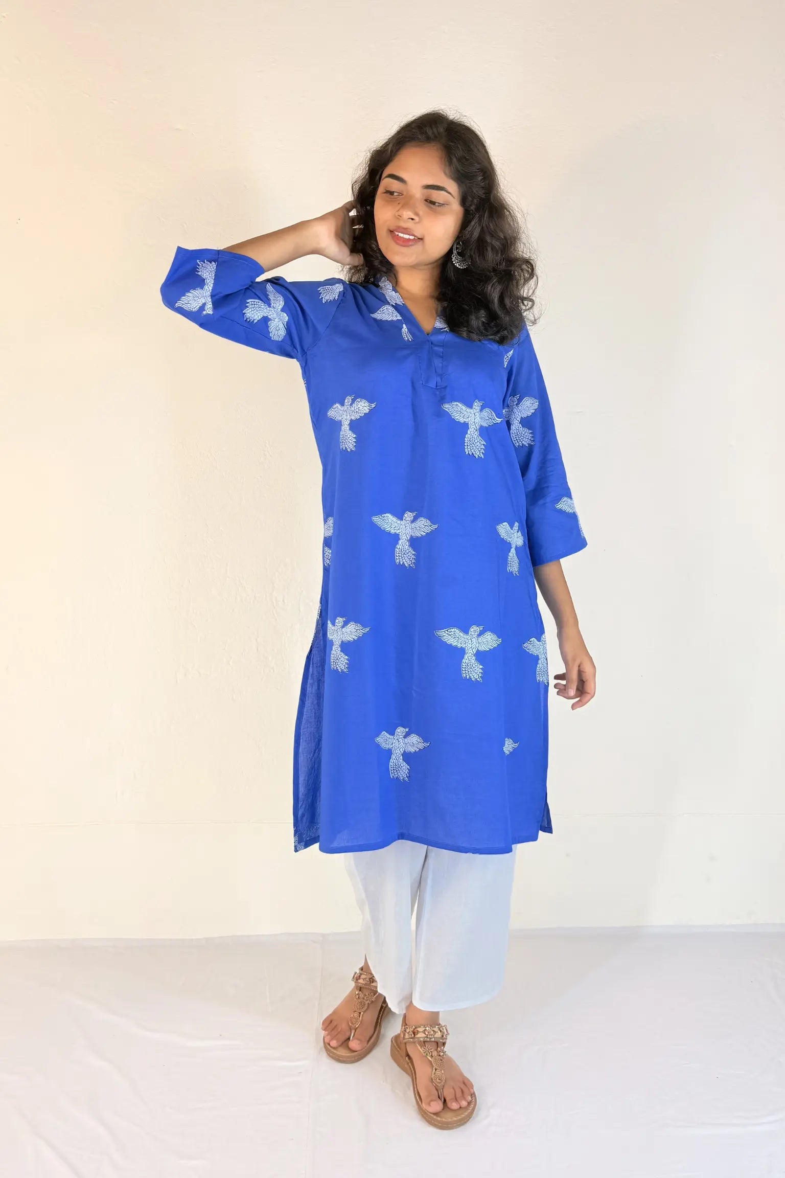 Woman wearing a blue kurta with white patterns on a white background
