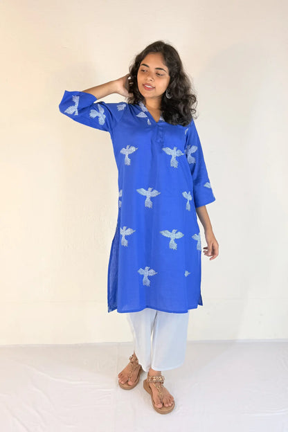 Woman wearing a blue kurta with white patterns on a white background