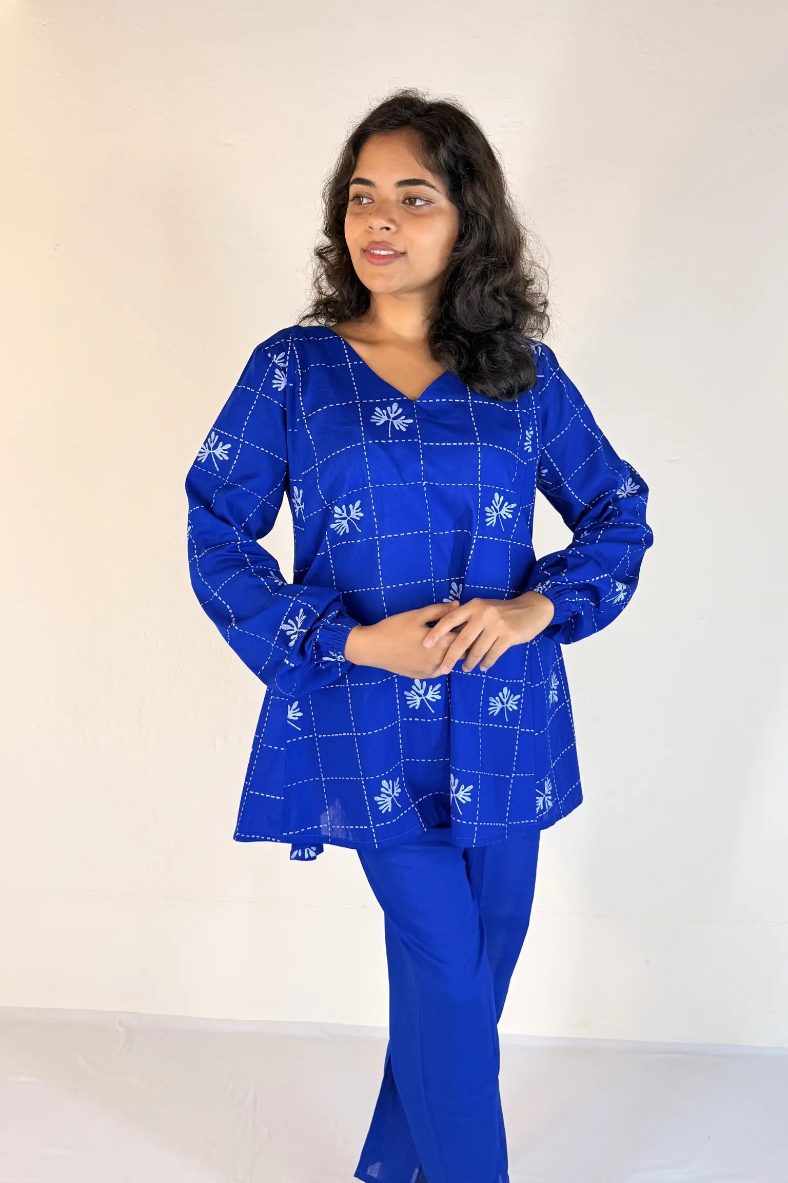 Woman wearing a blue checkered outfit with a white background