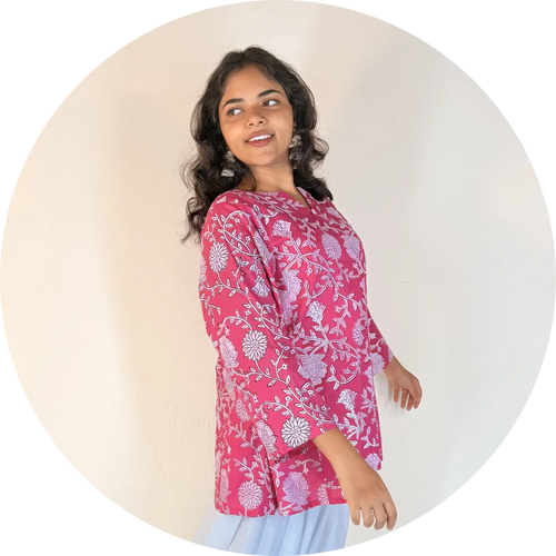 Woman wearing a pink floral patterned top against a white background