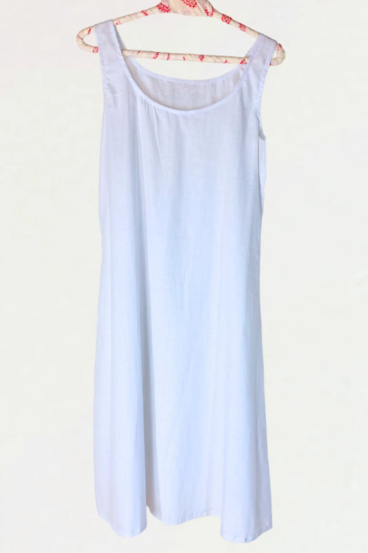 A light blue sleeveless slip dress hanging on a floral-patterned wooden hanger against a plain off-white background.
