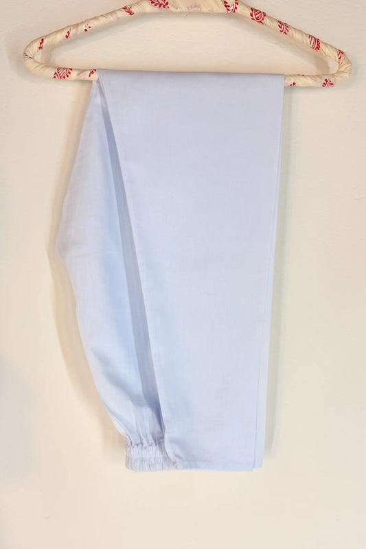 white pants on a hanger with a beige background