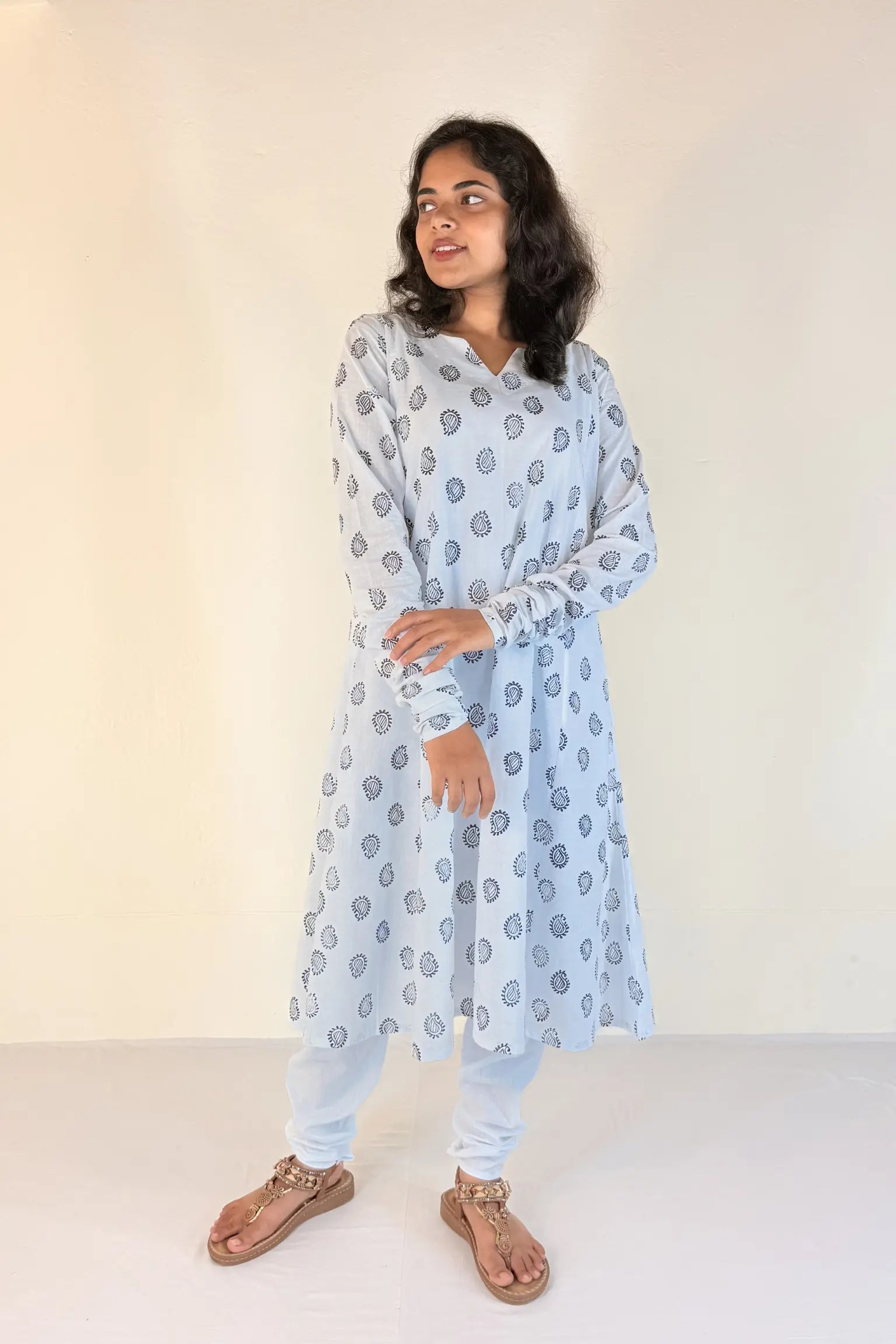 Woman wearing a light blue kurta with a subtle pattern against a white background