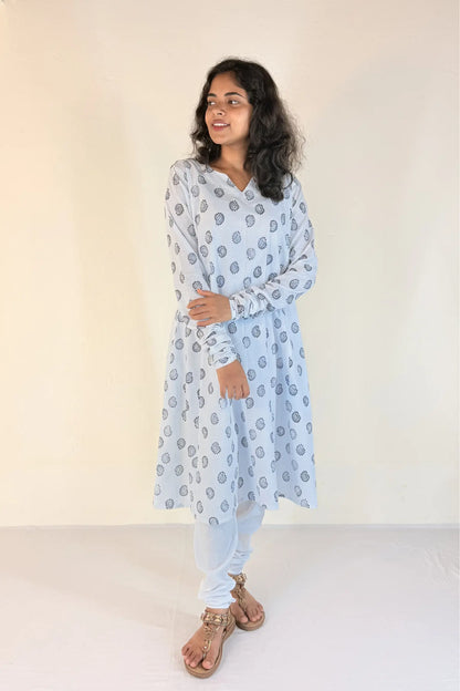 Woman wearing a light blue floral patterned kurta against a white background