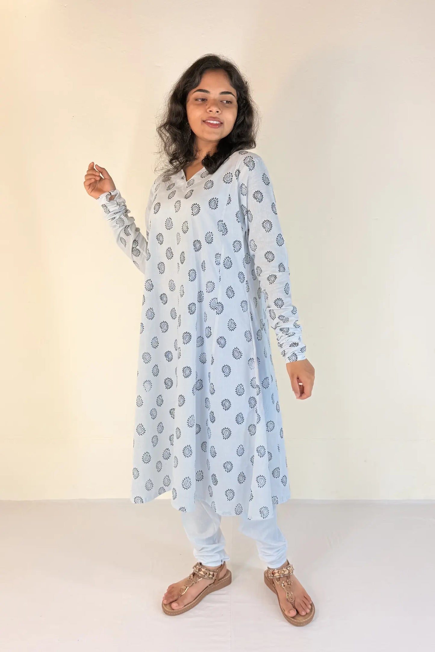 Woman wearing a light blue patterned outfit on a white background