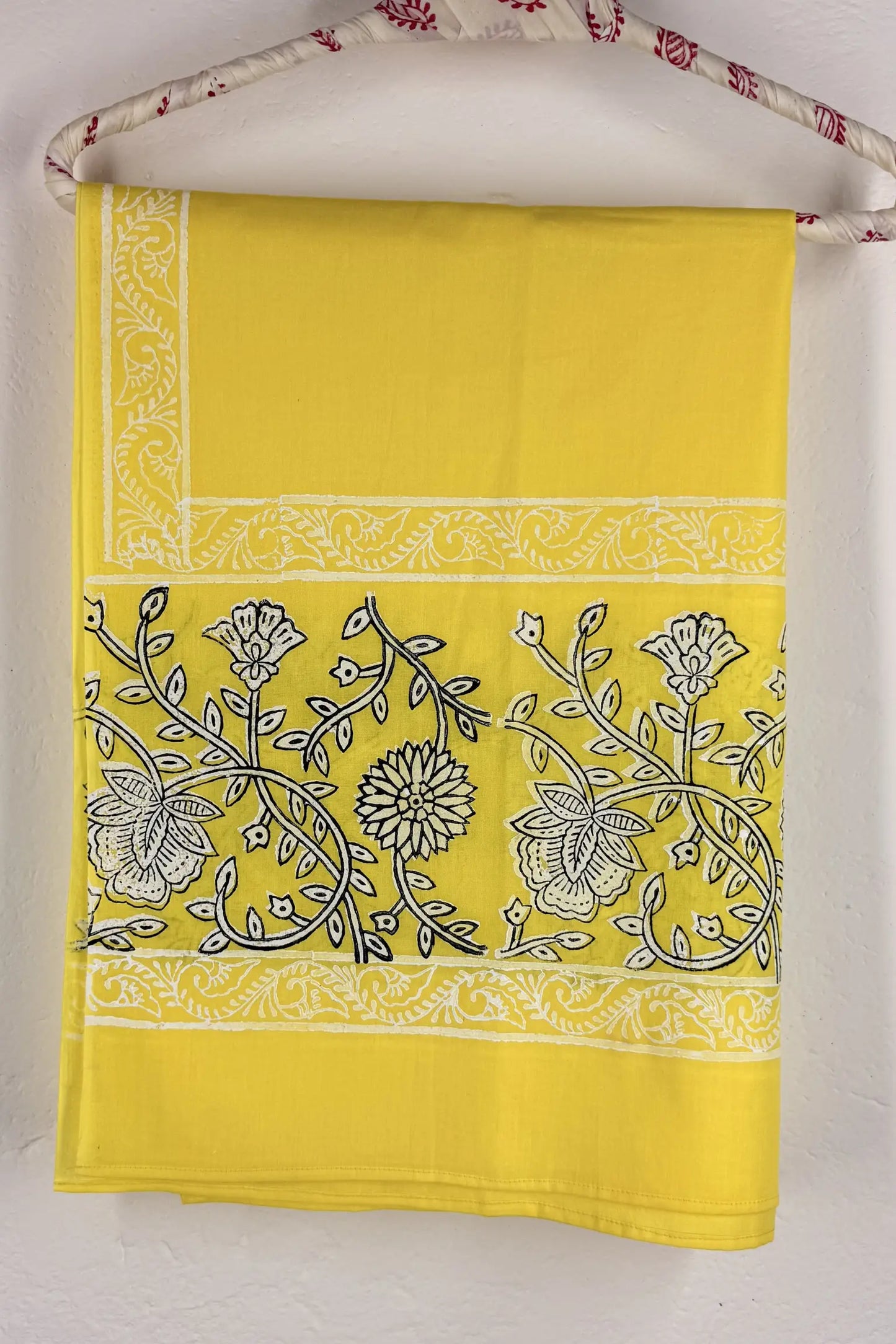 Yellow fabric with black floral patterns on a white background