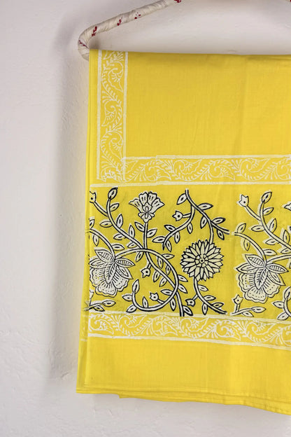 Yellow fabric with black floral patterns on a white background