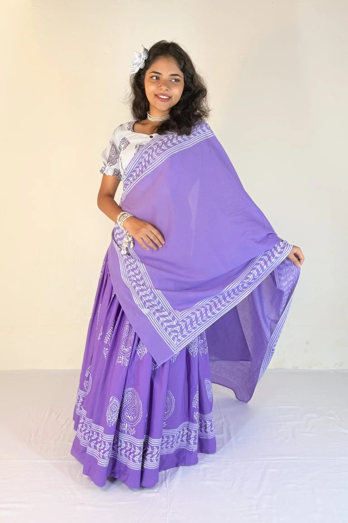 Woman wearing a purple Gopi Skirt Set with white patterns on a plain background