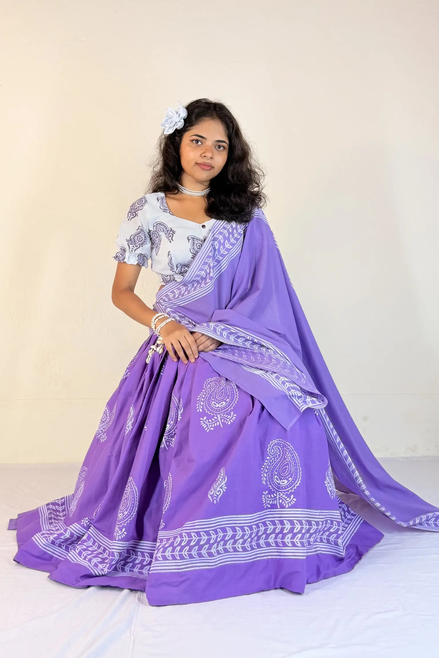 Woman wearing a purple Gopi Skirt Set with white patterns on a plain background