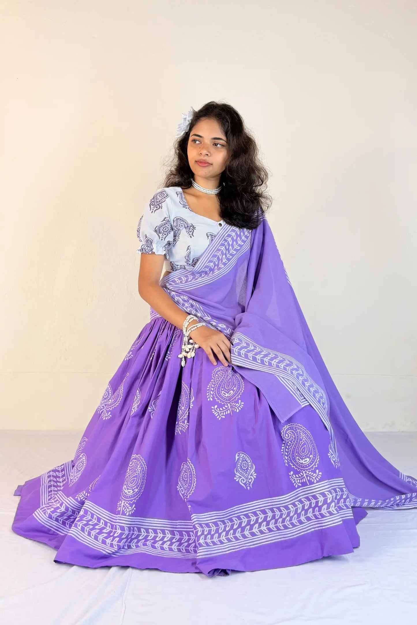 Woman wearing a purple Gopi Skirt Set with white patterns on a plain background