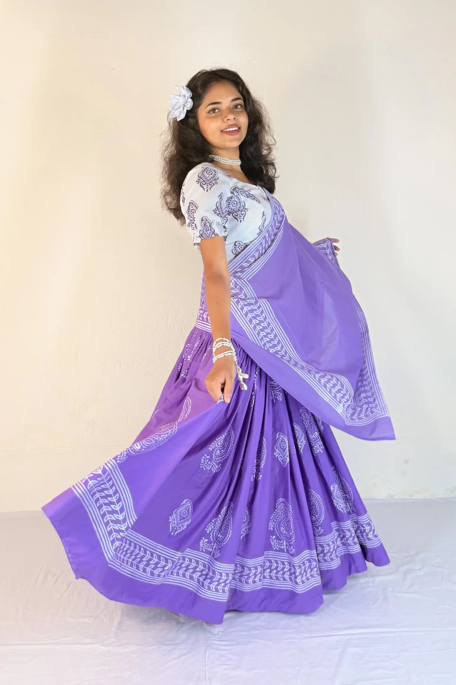 Woman wearing a purple Gopi Skirt Set with white patterns on a plain background