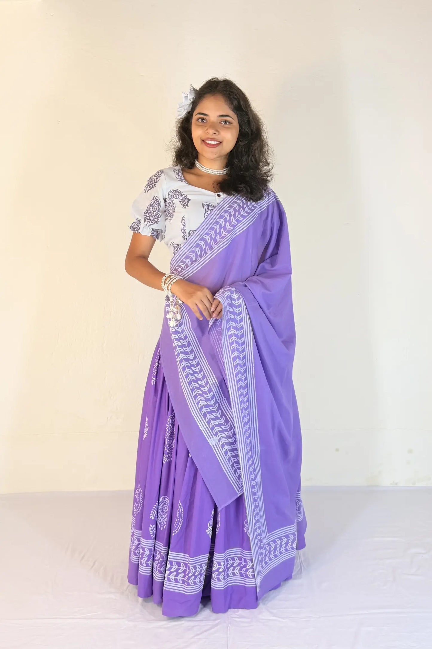Woman wearing a purple Gopi Skirt Set with white patterns on a plain background