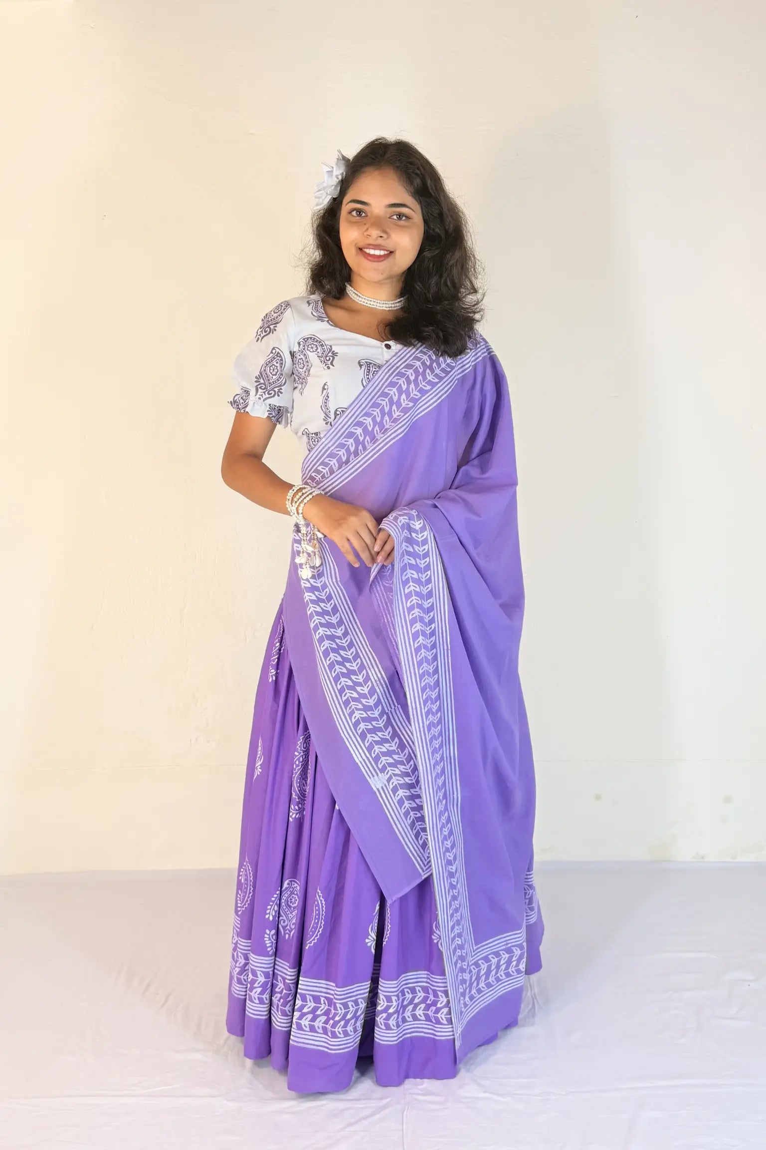Woman wearing a purple Gopi Skirt Set with white patterns on a plain background