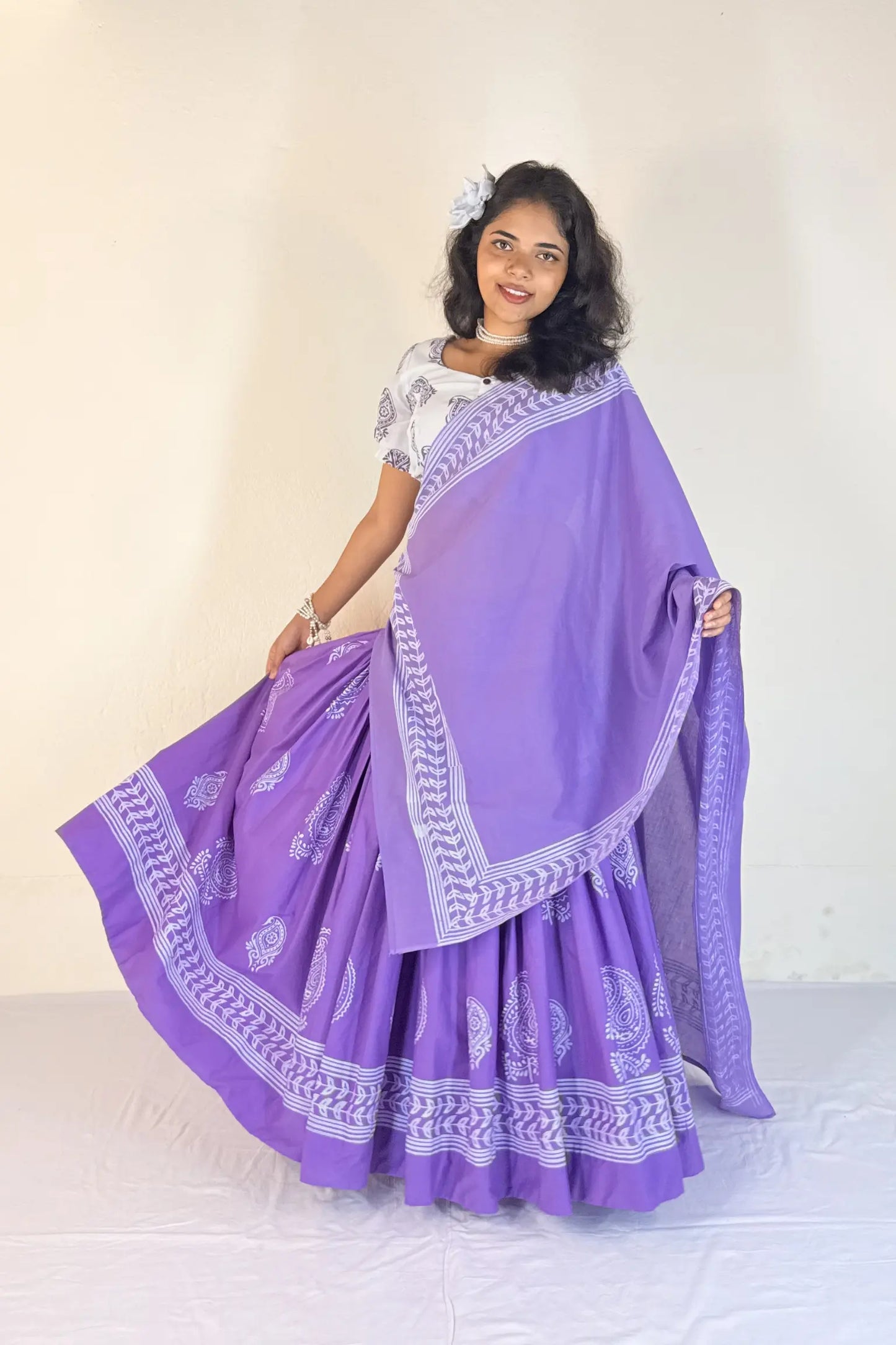 Woman wearing a purple Gopi Skirt Set with white patterns on a plain background