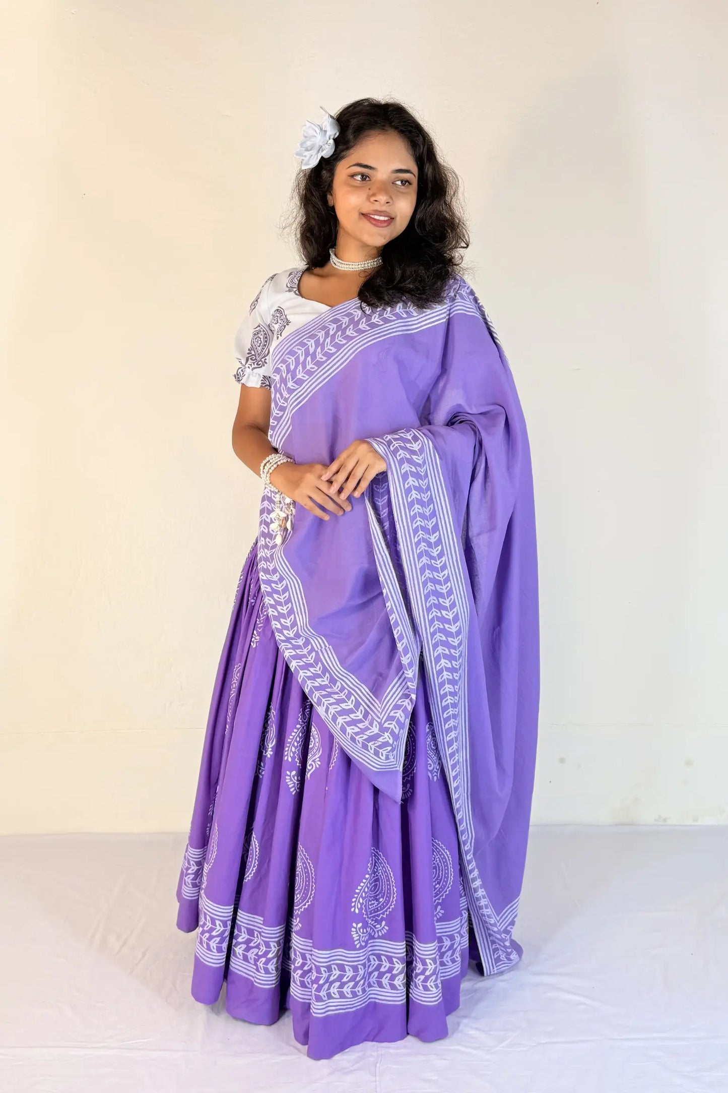 Woman wearing a purple Gopi Skirt Set with white patterns on a plain background