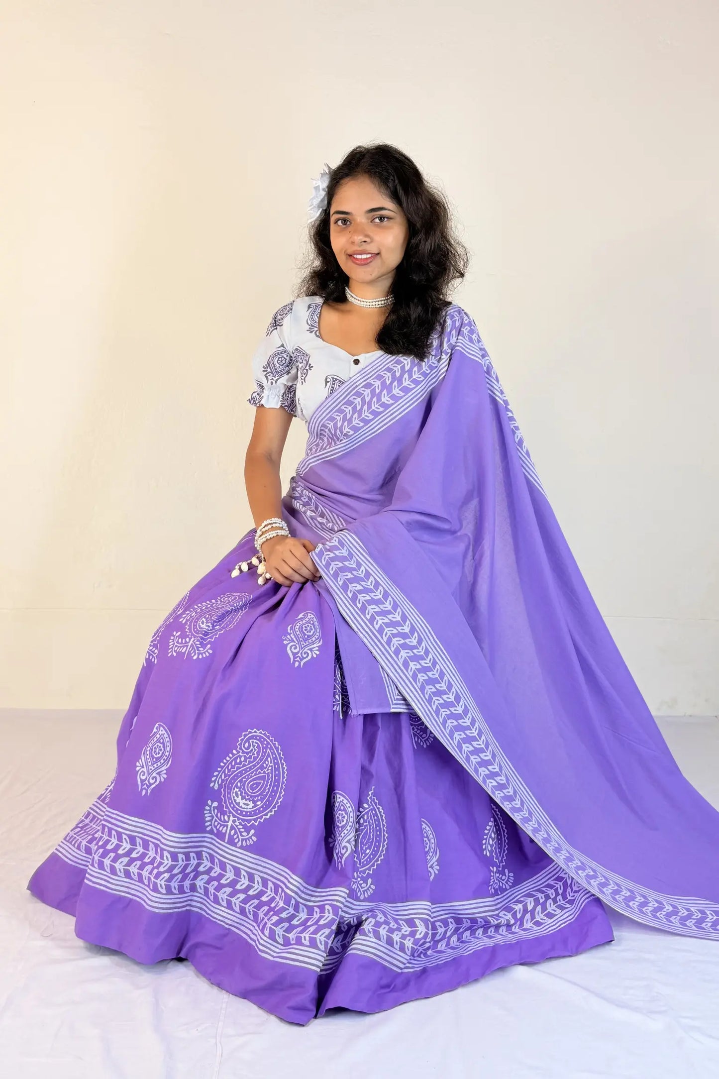 Woman wearing a purple Gopi Skirt Set with white patterns on a plain background