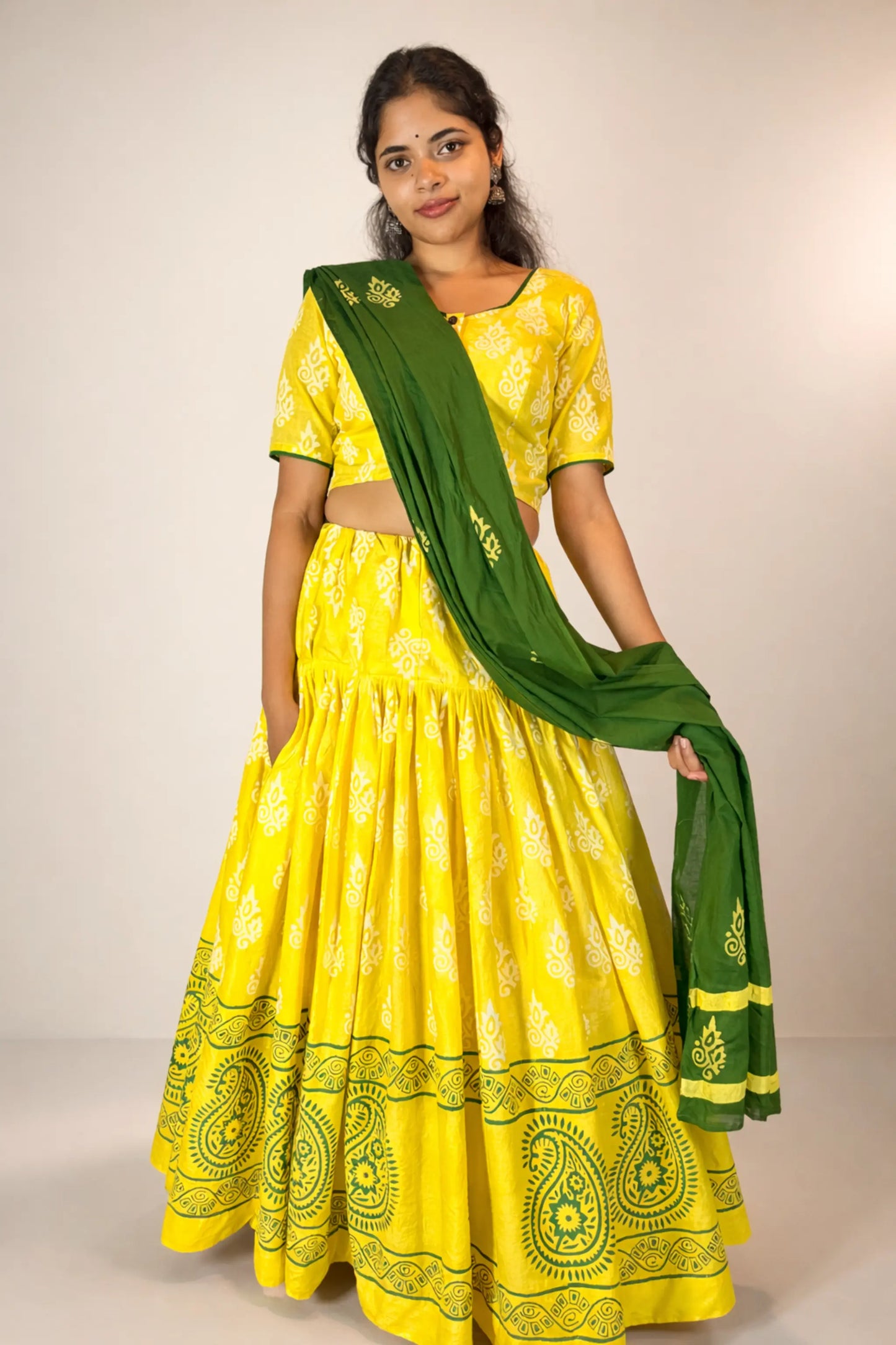 Front standing pose of Basantika yellow pure cotton gopi skirt set with green dupatta
