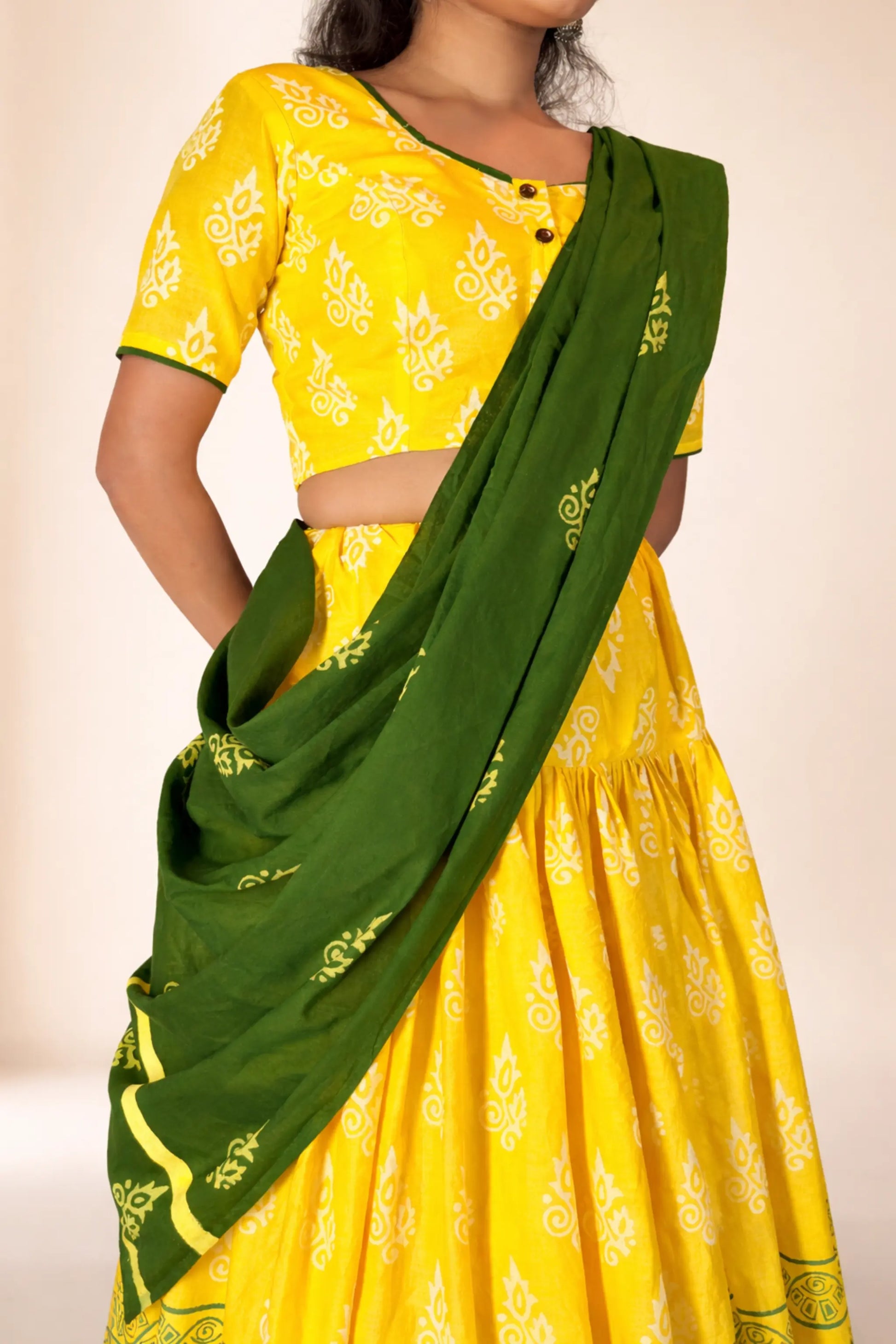 Angled upper body view of Basantika yellow and green hand block print gopi skirt set