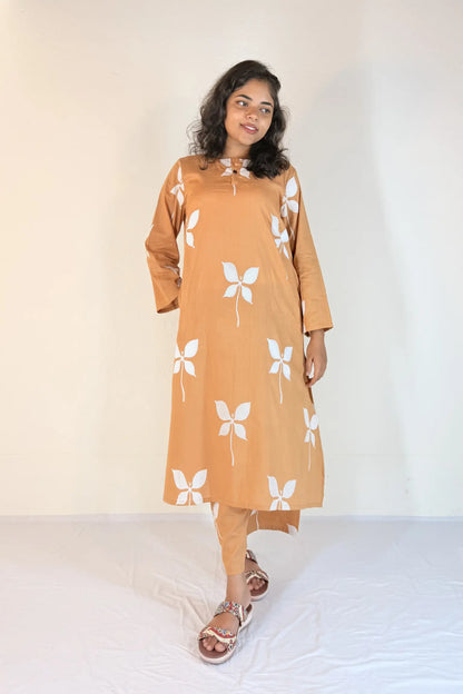 Woman wearing a mustard yellow kurta with white butterfly patterns on a plain background