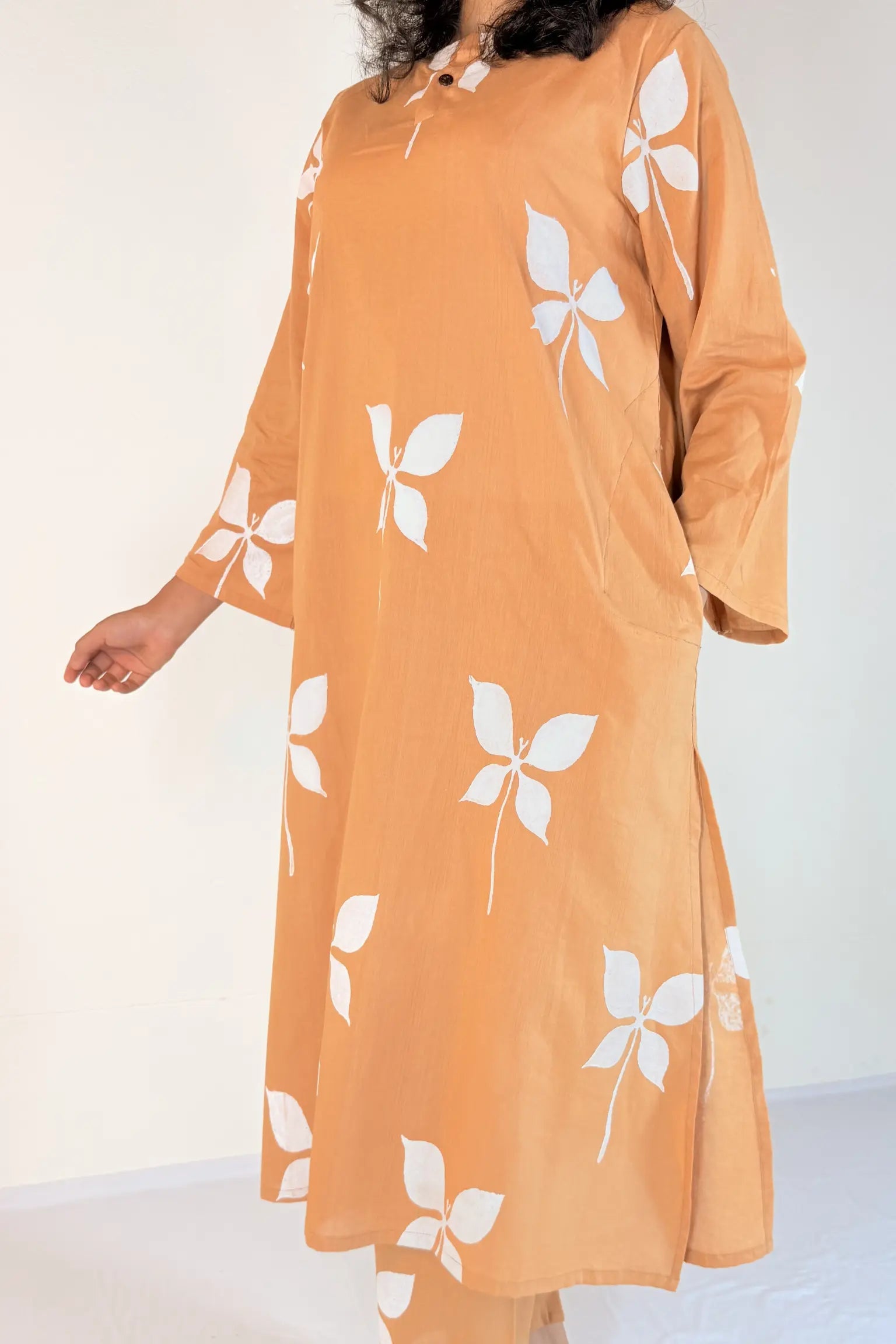 Orange dress with white floral patterns on a plain background